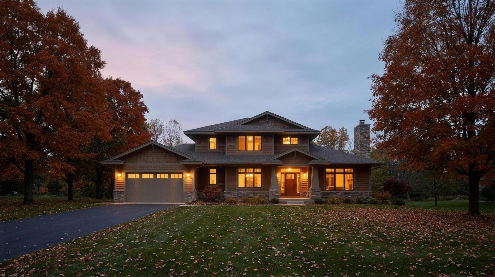 A craftsman home at dusk with fall color